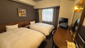 A hotel room with two beds, a desk with a telephone, a television, and a window with curtains. - Hotel Route-Inn Gotenba Ekiminami (Gotemba)
