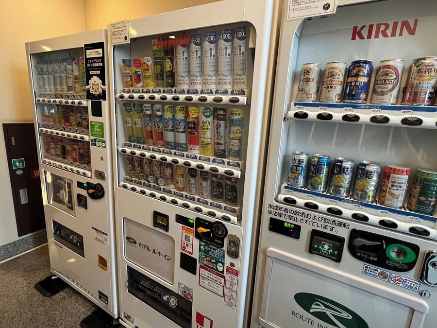 Máquinas expendedoras con diversas bebidas y aperitivos, incluyendo cerveza Kirin y bebidas energéticas.