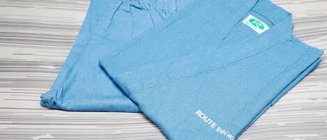 Two folded blue towels with a logo and text on them, placed on a wooden surface.