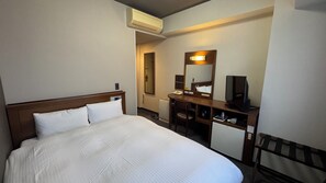A hotel room with a bed, a desk, a chair, a television, and an air conditioning unit. - Hotel Route-Inn Gotenba Ekiminami (Gotemba)