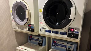 A laundry facility with two front-loading washing machines and two stacked dryers. - Hotel Route-Inn Gotenba Ekiminami (Gotemba)