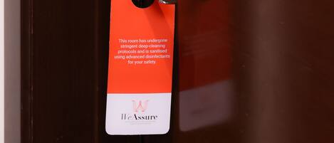 A hotel room door with a safety sign and a keycard slot.