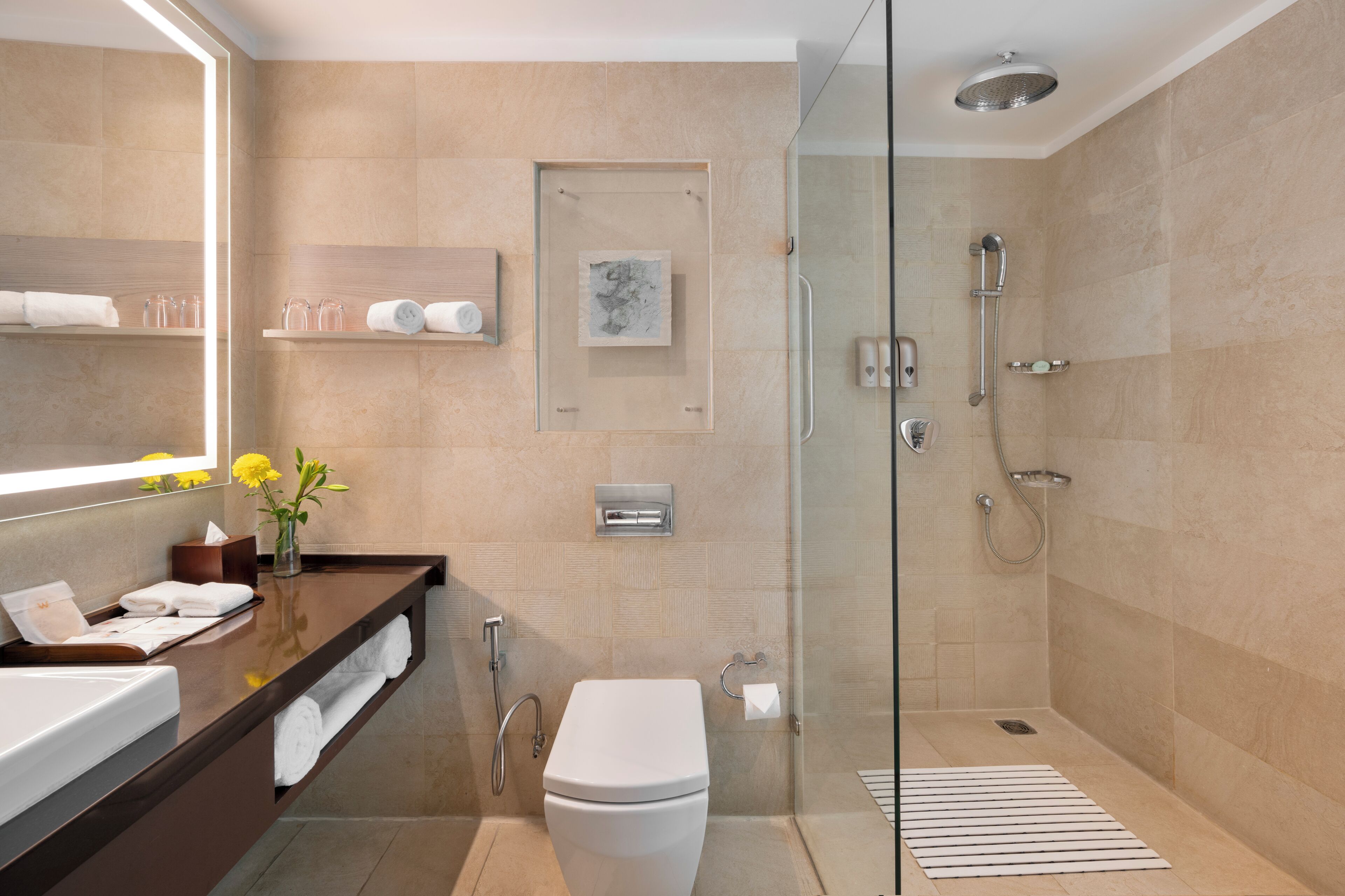 A modern bathroom with a glass-enclosed shower, a white toilet, a vanity with a mirror, and a towel rack.