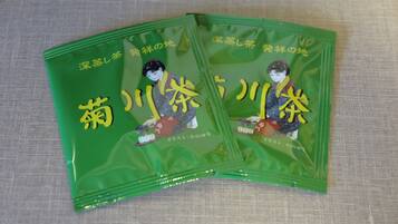 Two green packages with Japanese text and an illustration of a person.