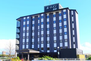 A multi-story hotel with a modern design, featuring a prominent entrance and a sign with Japanese characters.