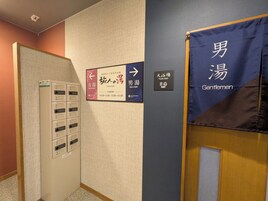 A public bath area with directional signs for women's and men's baths, and a sign indicating the men's bath is for gentlemen.