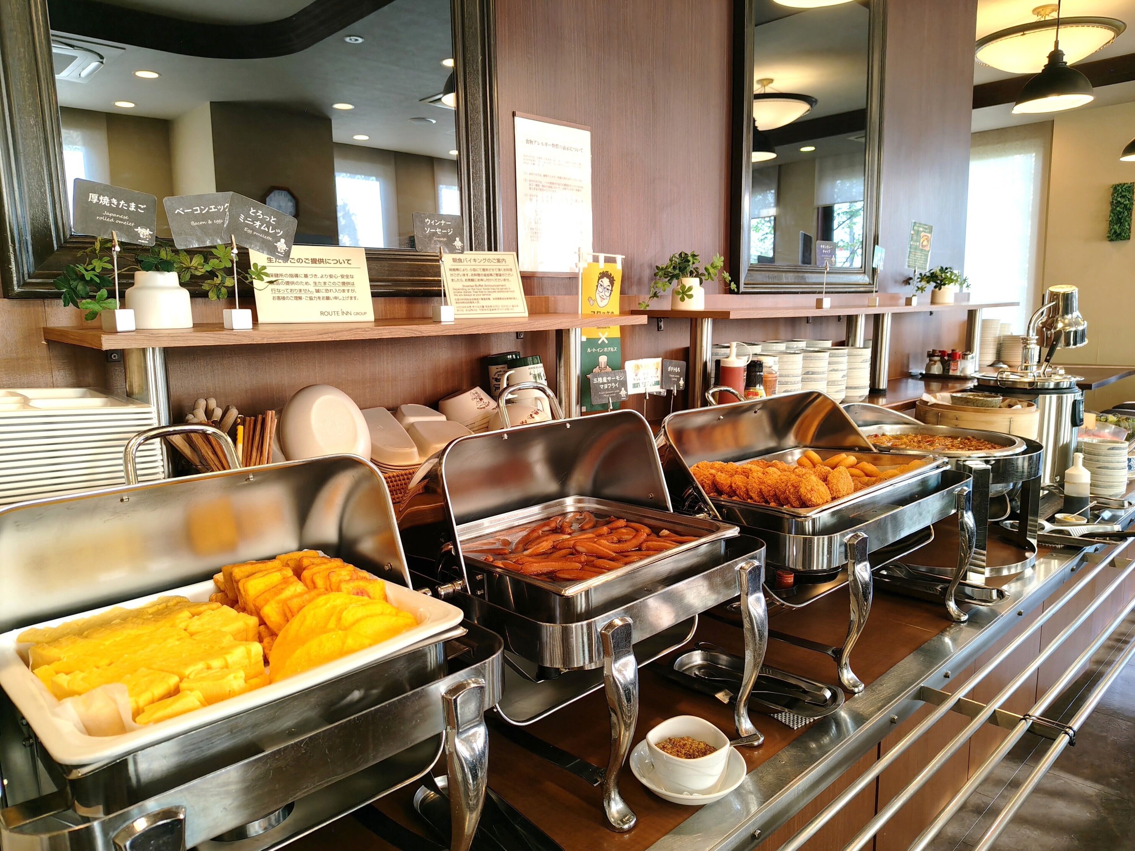 A buffet area with various food options, including fried items and a bowl of sauce.