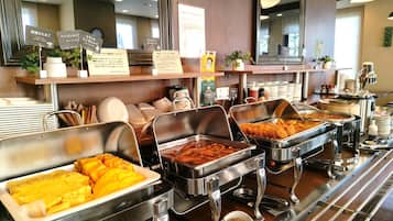 A buffet area with various food options, including fried items and a bowl of sauce.