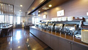 A buffet area with multiple self-service stations, a long counter, and a seating area with tables and chairs. - Hotel Route Inn Ishinomaki Kanan Inter (Isinomaki)