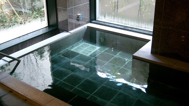 A glass-bottomed hot tub with a view of greenery outside. - Hotel Route Inn Aizuwakamatsu (Aizuwakamatsu)