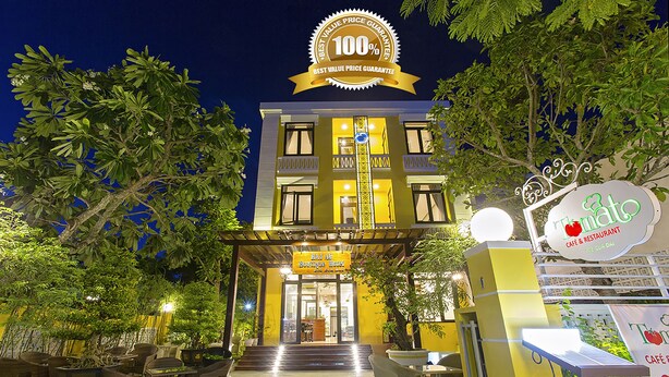 Un edificio de dos plantas con un cartel que indica una garantía de precio de mejor valor 100%.