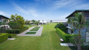 A well-maintained garden with a central lawn, pathways, and a seating area.