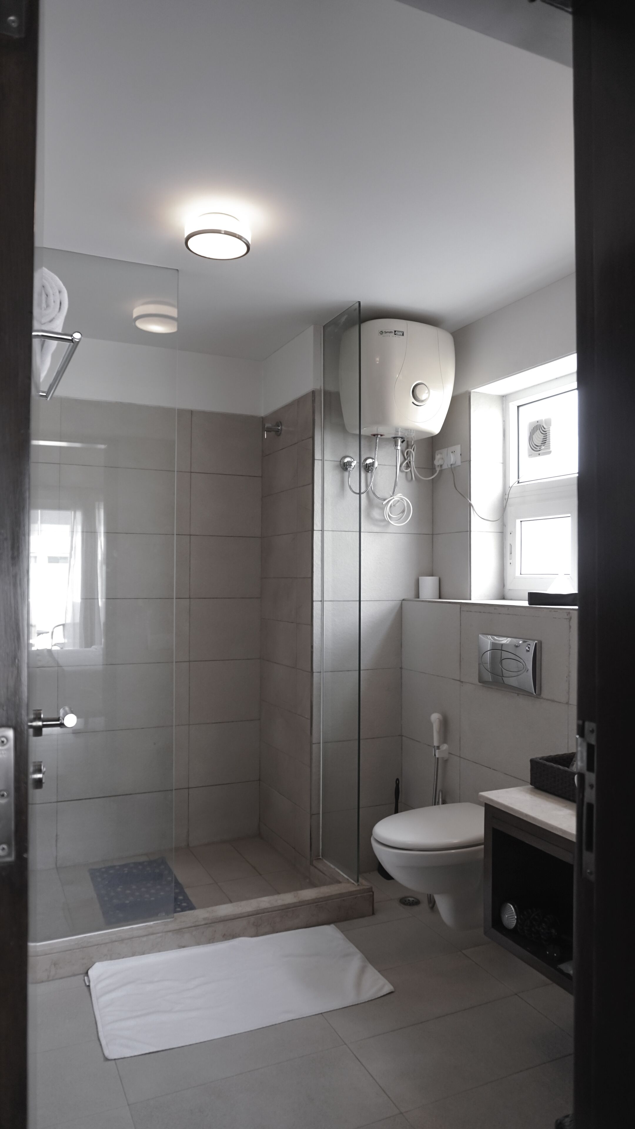 Ein modernes Badezimmer mit einer gläsernen Duschkabine, einer Toilette und einem Waschbecken.