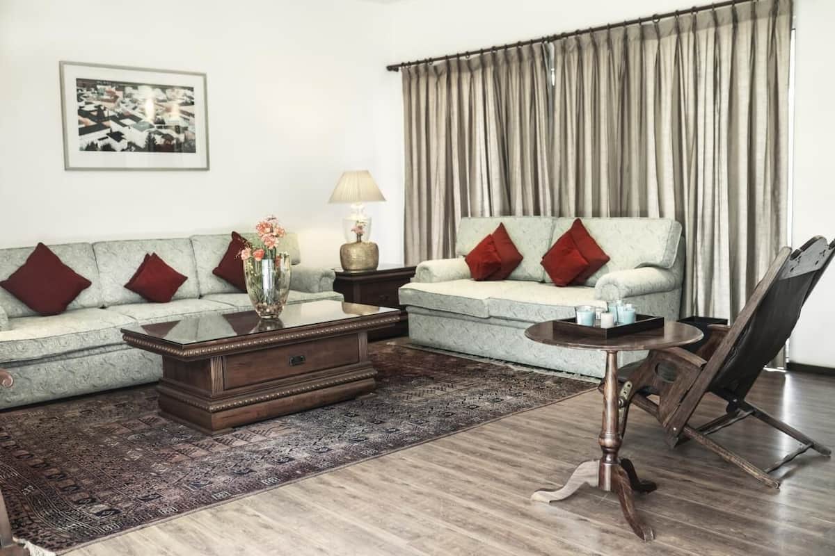 A living room with a sofa, coffee table, and a painting on the wall.
