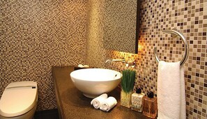 Un baño con un lavamanos grande, un inodoro y un perchero para toallas.