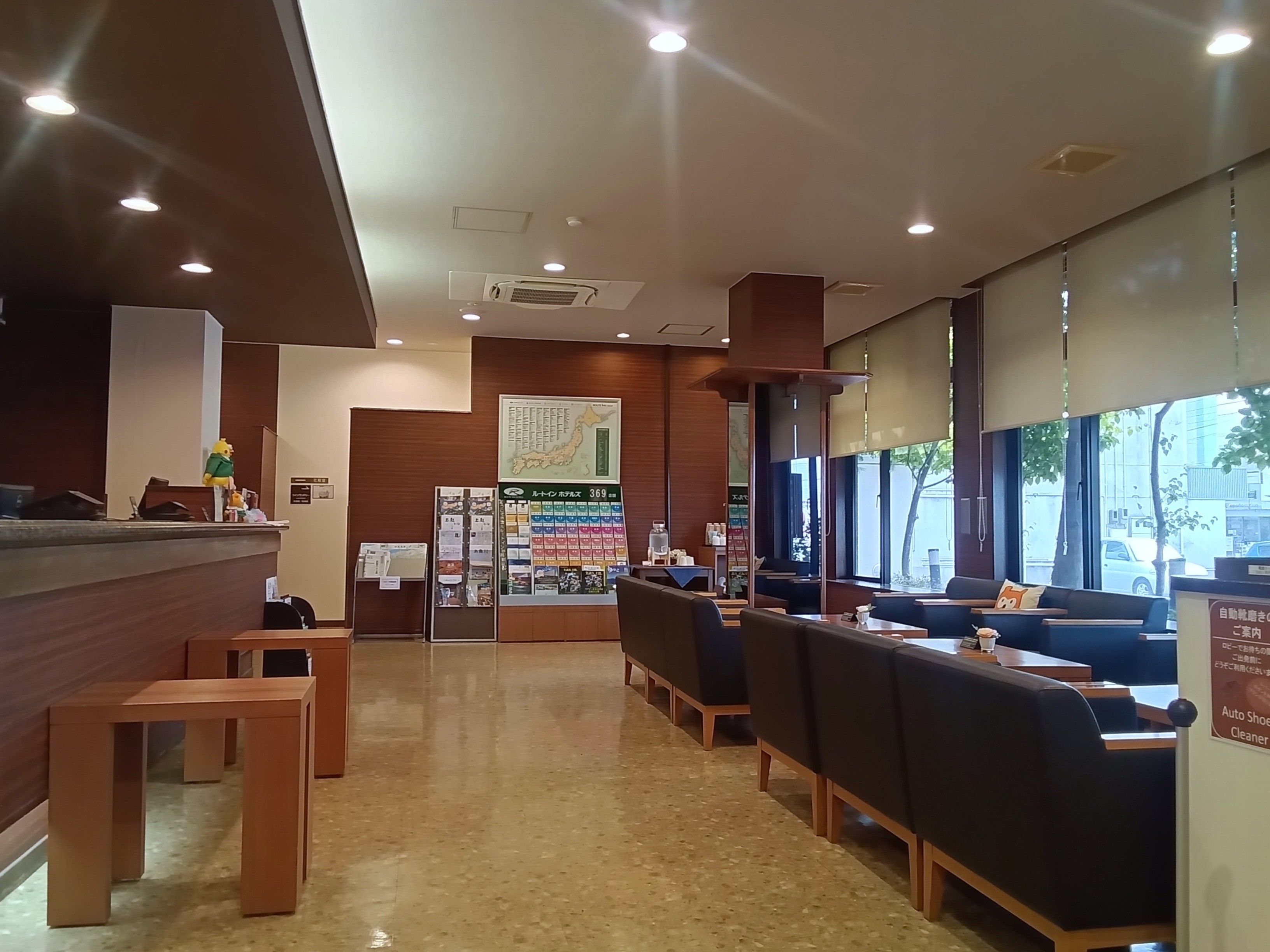 A restaurant interior with a reception desk, seating area, and a large window.
