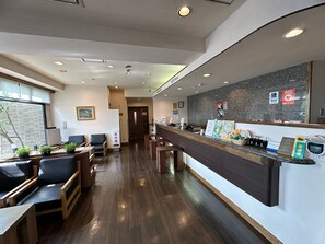 A reception area with a counter, seating, and a view of the outside.