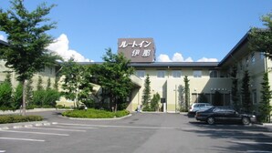 A building with a sign reading "ルートイン" and "伊那".