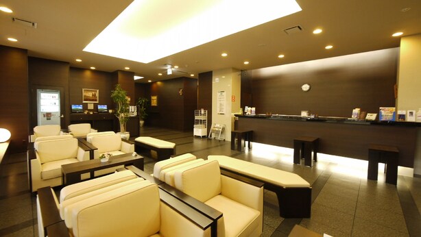 A hotel lobby with seating areas, a reception desk, and a large illuminated ceiling. - Hotel Route Inn Ina Inter (Minamiminowa)