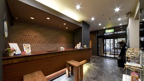 Un espace d’accueil avec un comptoir en bois, un banc et un présentoir pour les menus.
