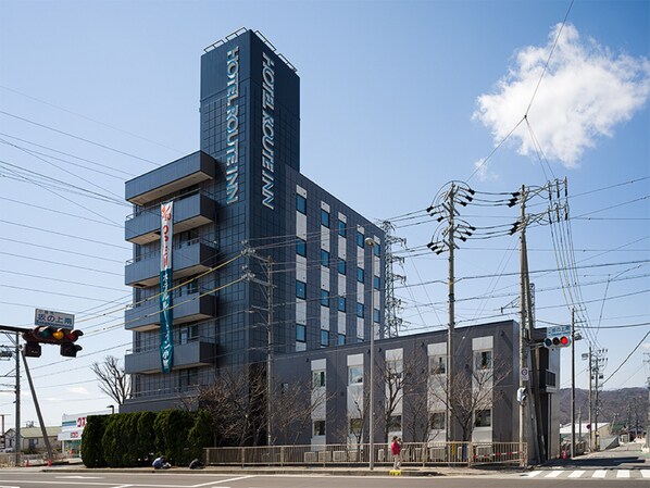 A multi-story hotel with a modern design, featuring a prominent vertical sign on the facade. - Hotel Route-Inn Komoro (Komoro)