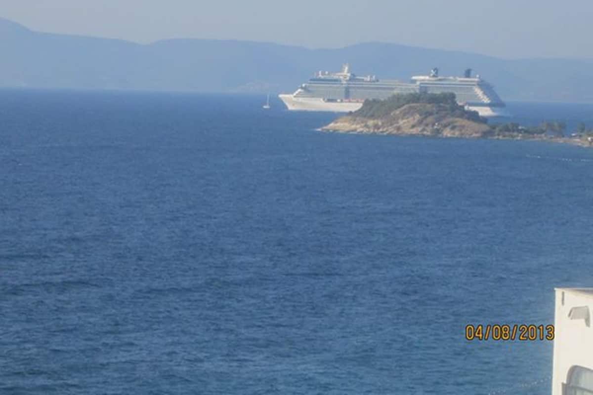 Un crucero amarrado en un puerto con montañas al fondo.