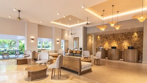 Un vestíbulo amplio con asientos modernos, una zona de recepción y grandes ventanales con vistas al exterior.