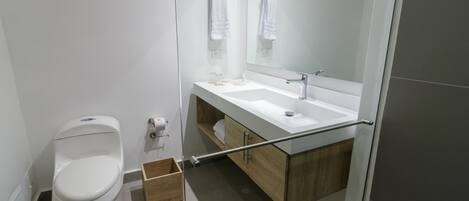 A modern bathroom with a toilet, sink, and mirror.