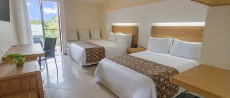 Una habitación de hotel con dos camas, un escritorio, una silla y una mesita.