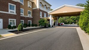 Un hôtel à plusieurs étages, doté d’une entrée couverte et d’une façade en briques.