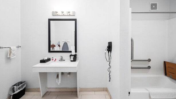 Une salle de bain moderne avec un lavabo blanc, un miroir et un porte-serviettes.