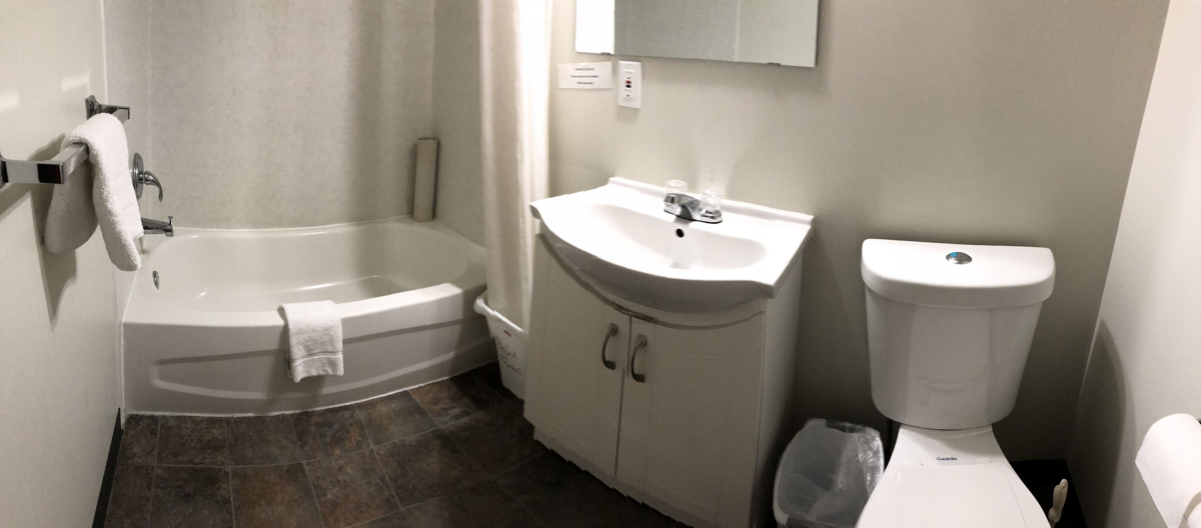 Un baño con bañera, lavamanos e inodoro.