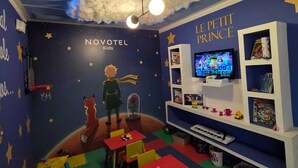 A children's room at Novotel Kids with a starry wall, a TV, and a bookshelf. - Novotel Bogotá Parque 93 (Bogotá)