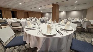 A banquet hall with round tables set for dining, equipped with white tablecloths, plates, glasses, and napkins. - Novotel Bogotá Parque 93 (Bogotá)