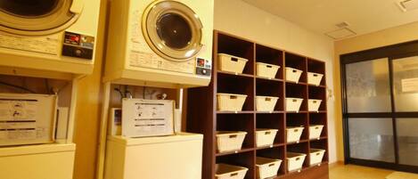 A laundry room with a washing machine, dryer, and storage shelves.