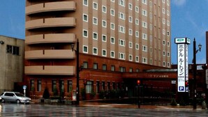 Un hôtel à plusieurs étages, doté d’un toit végétalisé bien visible et d’une rangée de fenêtres à chaque étage.