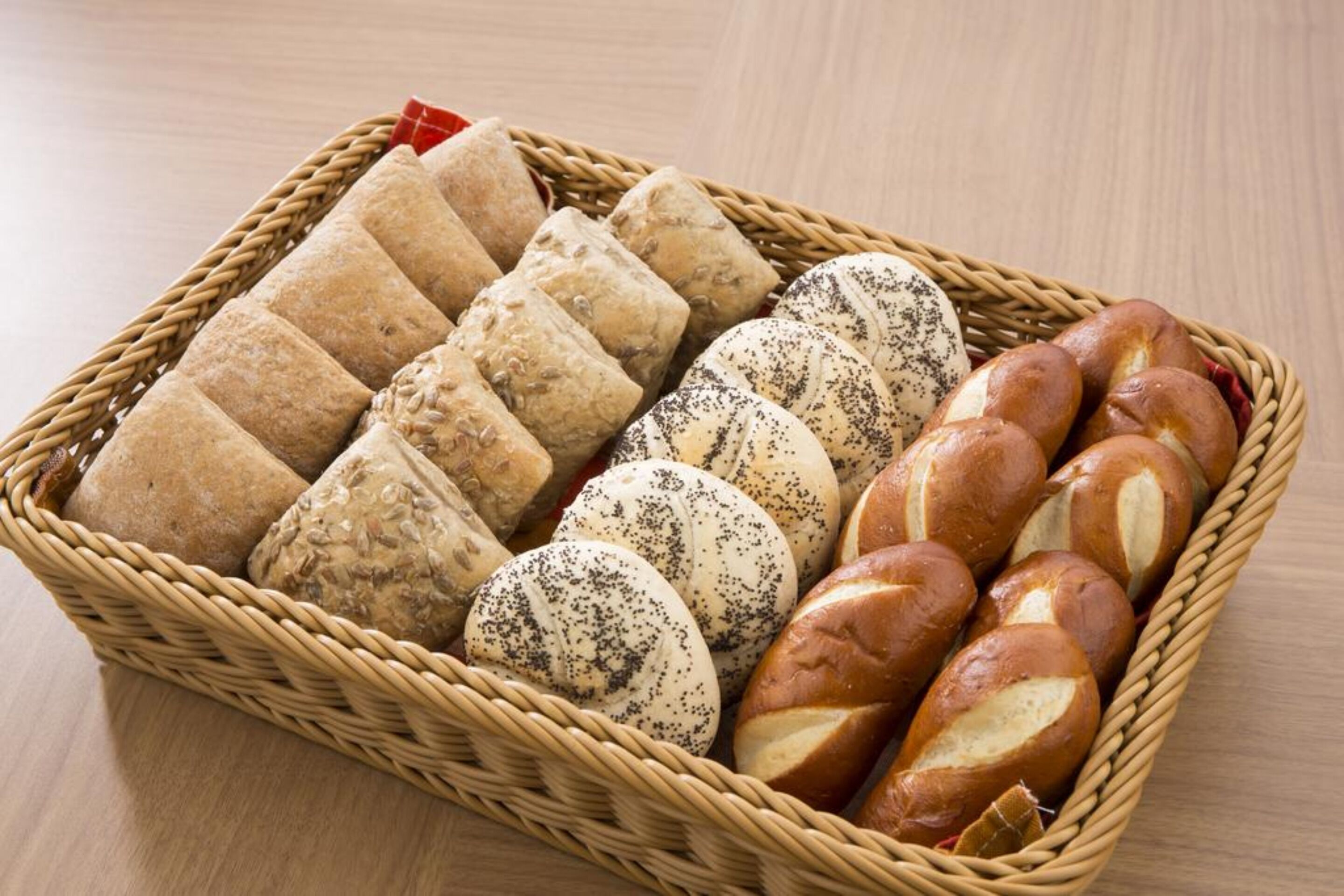 A wicker basket containing various types of bread.