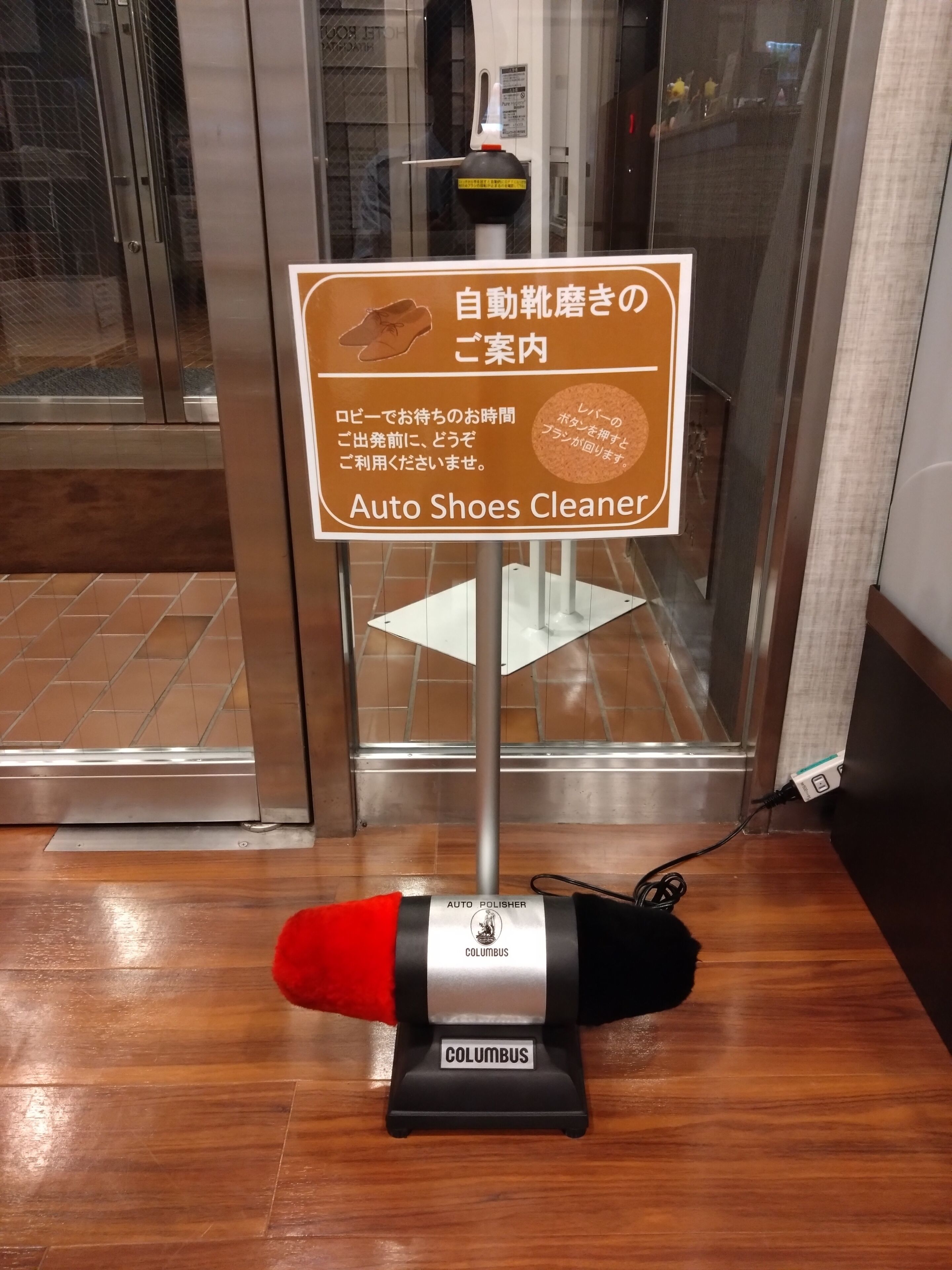 An auto shoe cleaner with a sign indicating it's for shoes inside the hotel.