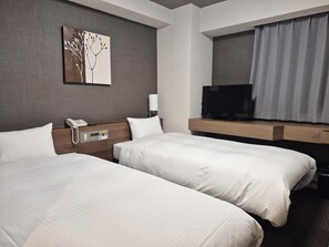 A hotel room with two beds, a bedside telephone, a flat-screen TV, and a painting on the wall. - Hotel Route Inn Hitachitaga (Hitachi)