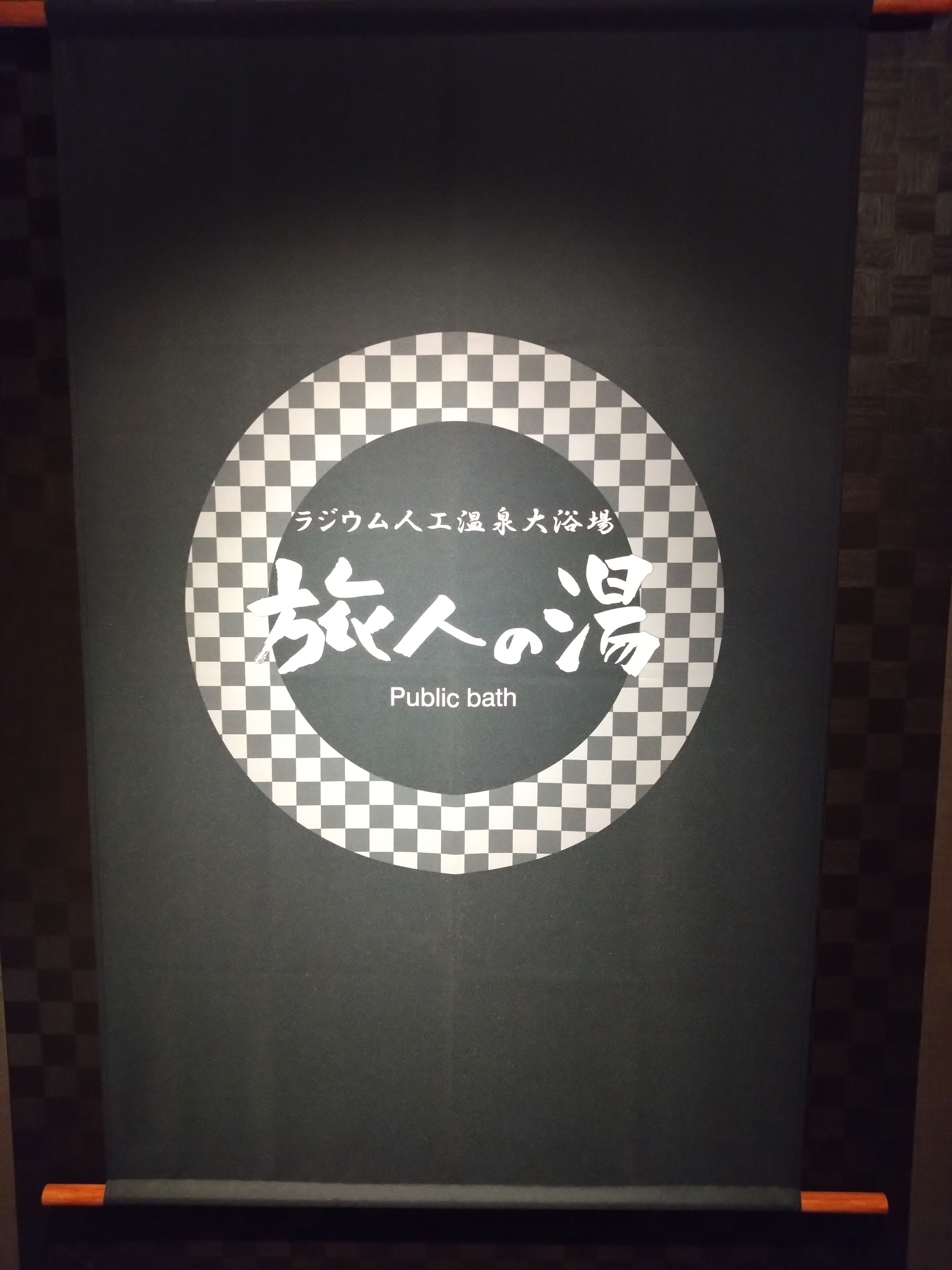 A sign with Japanese text and the English translation "Public bath".