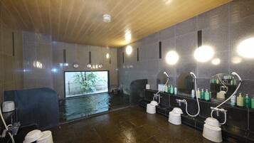 Un baño moderno con techo de madera, varios lavamanos y un espejo grande.