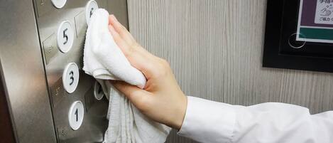 Eine Hand drückt Aufzugstasten.