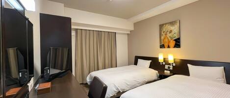 A hotel room with two beds, a desk with a computer, a mirror, and a painting on the wall.
