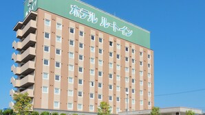 A multi-story hotel with a green roof and beige facade, featuring numerous windows and balconies. - Hotel Route-Inn Odate Eki Minami (Odate)