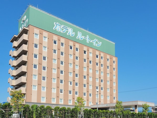 A multi-story hotel with a green roof and beige facade, featuring numerous windows and balconies. - Hotel Route-Inn Odate Eki Minami (Odate)