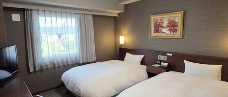 A hotel room with two beds, a desk, a television, a window with curtains, a painting on the wall, and a ceiling light.