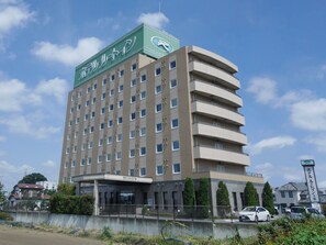 Un hotel de varios pisos con un cartel verde llamativo en la parte superior.