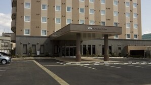 Un edificio de hotel de varios pisos con fachada plana y techo verde.