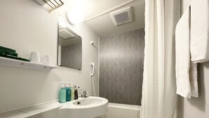 A bathroom with a sink, mirror, shower, and towel rack.