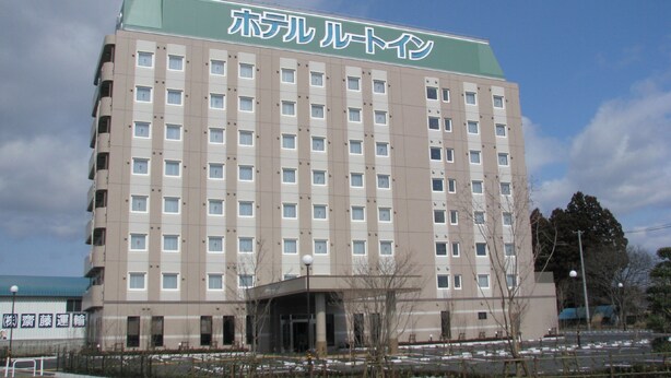 Un hôtel à plusieurs étages, doté d’une façade sobre, de nombreuses fenêtres et d’un toit végétalisé.